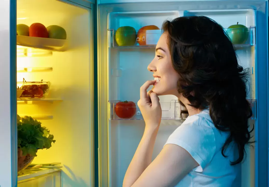 girl looks in the fridge while losing weight fast